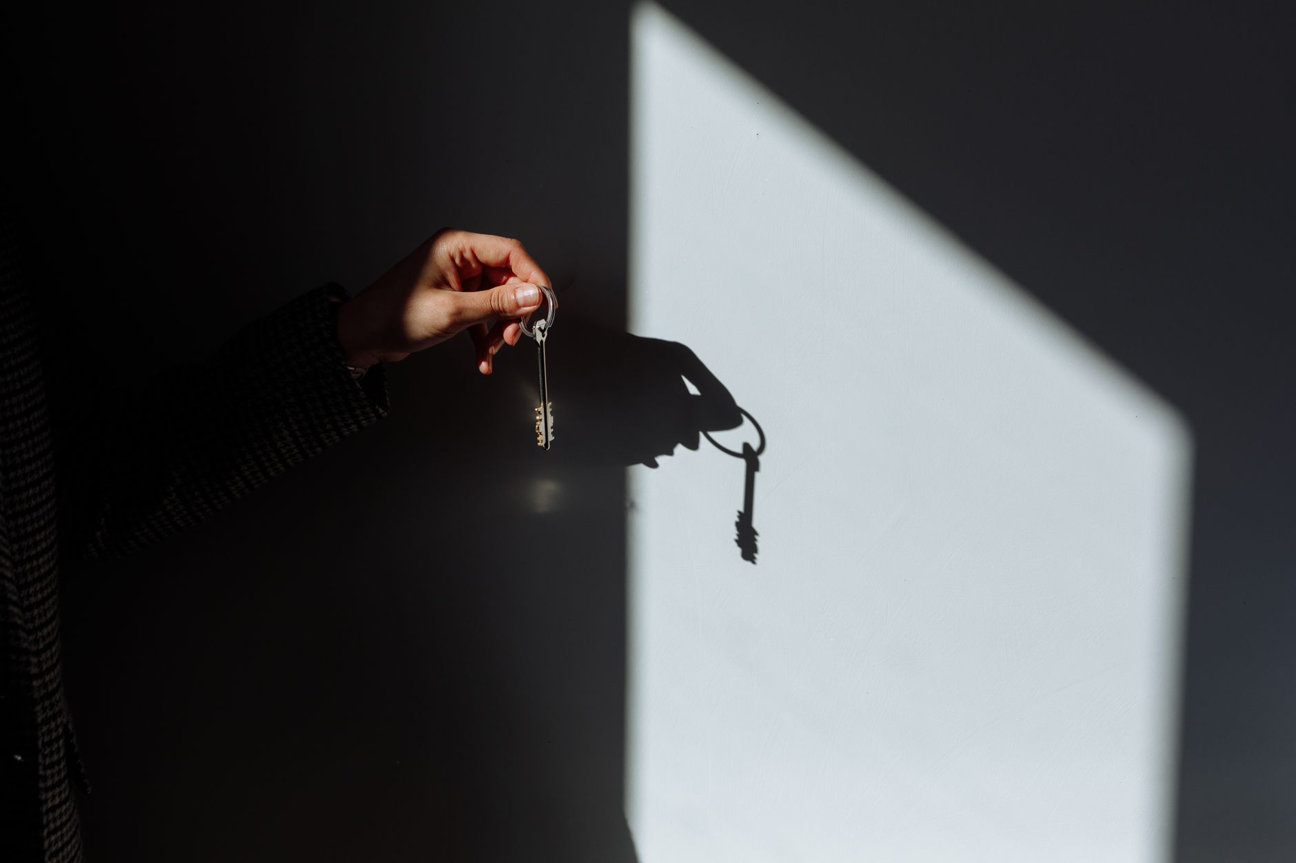 hand holding a house key with a DPE certificate in background