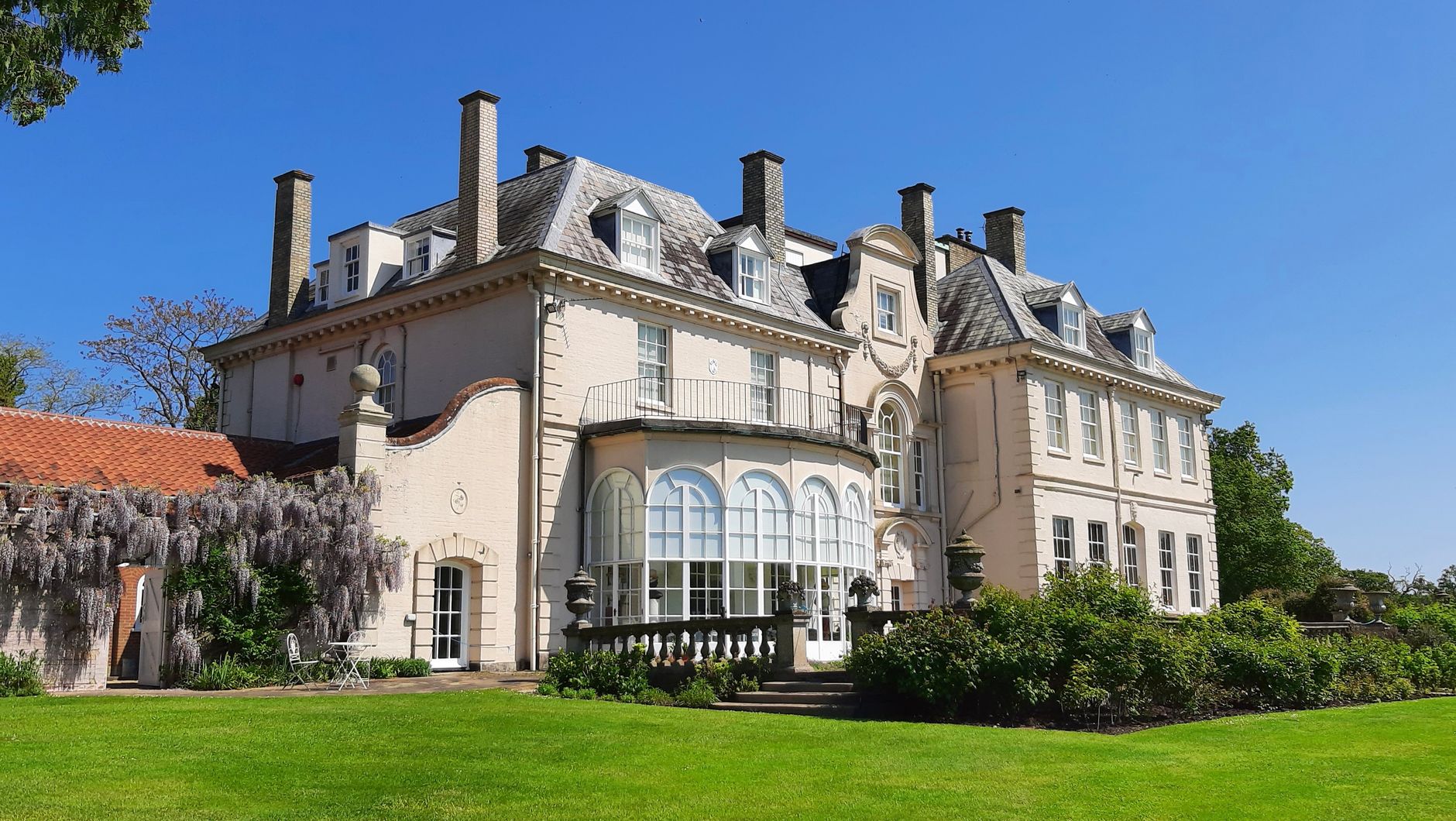 elegant mansion exterior, green garden, sunny day