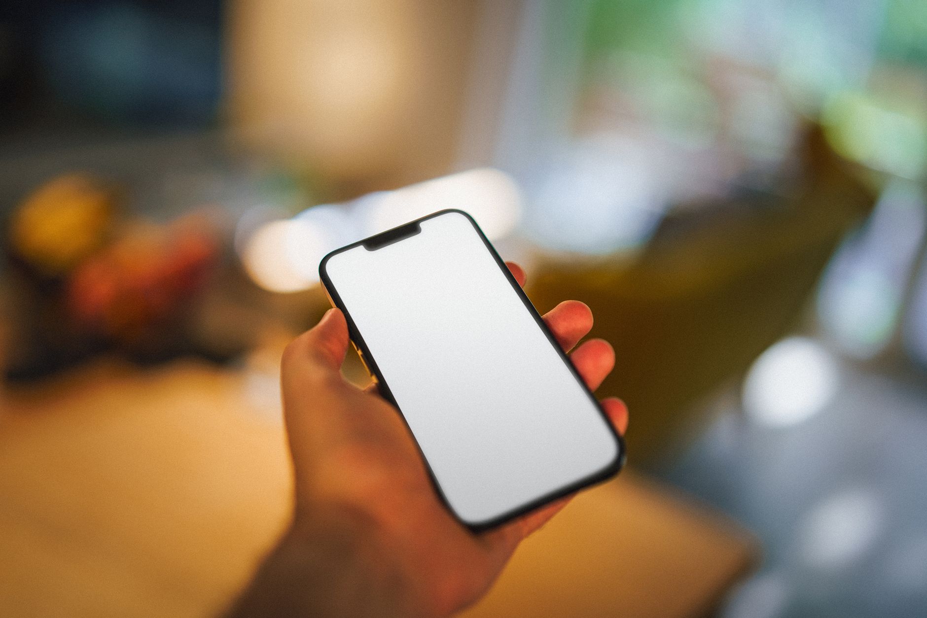 person holding smartphone and looking at reviews on screen, blurred background of real estate listing