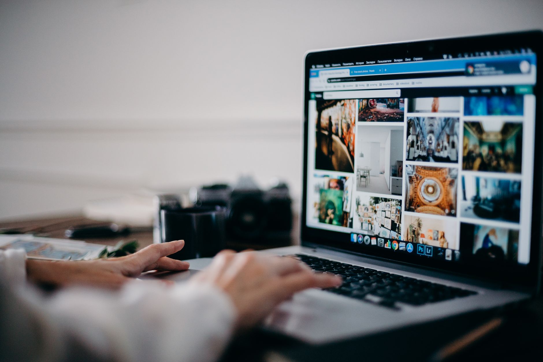person searching on laptop with various icons of job, house, car on screen
