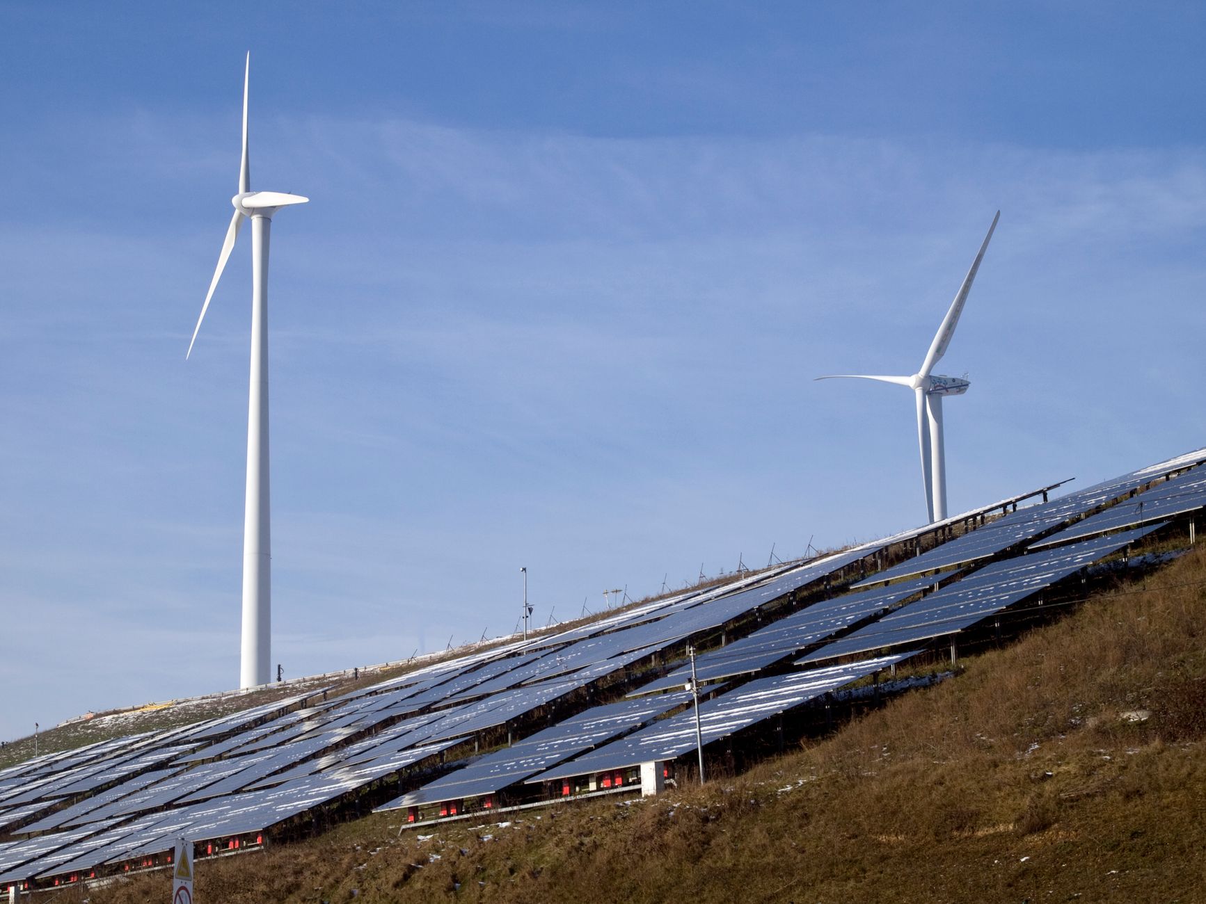 solar panels and wind turbines with blue sky, representing renewable energy